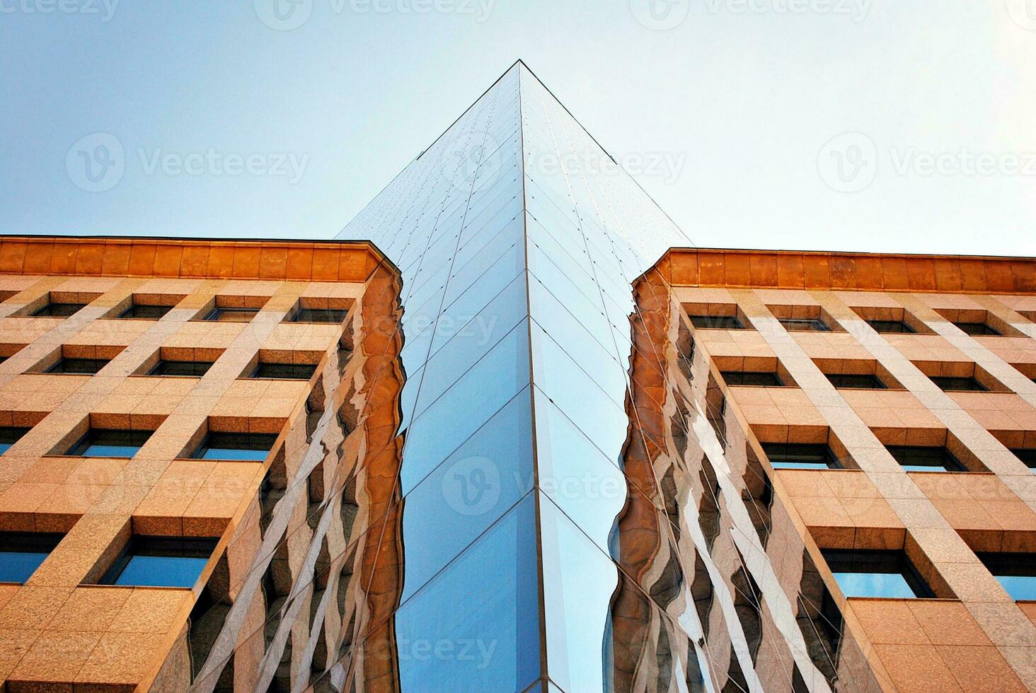 Structural glass wall reflecting blue sky. Abstract modern architecture fragment photo