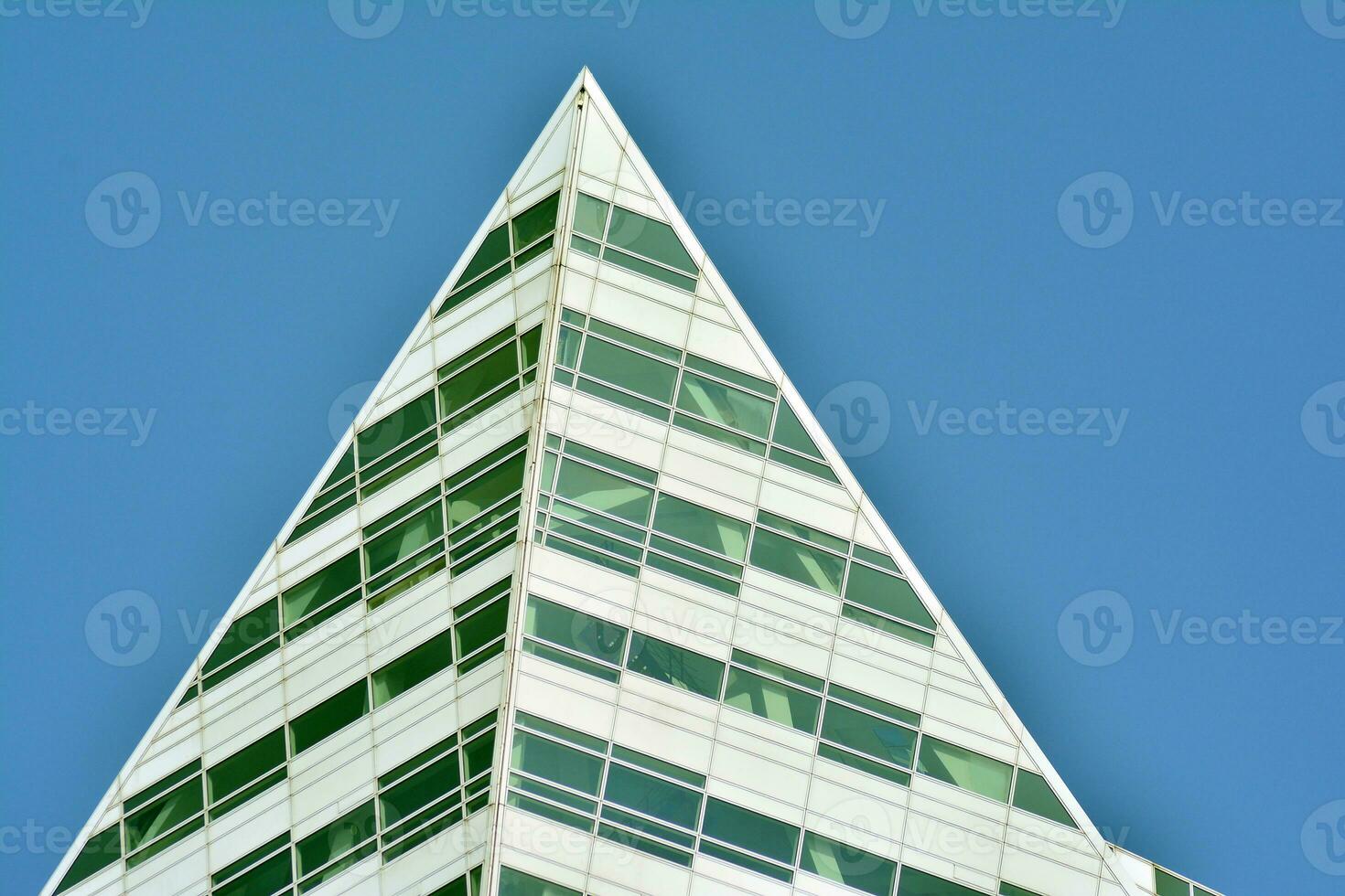 Structural glass wall reflecting blue sky. Abstract modern architecture fragment photo