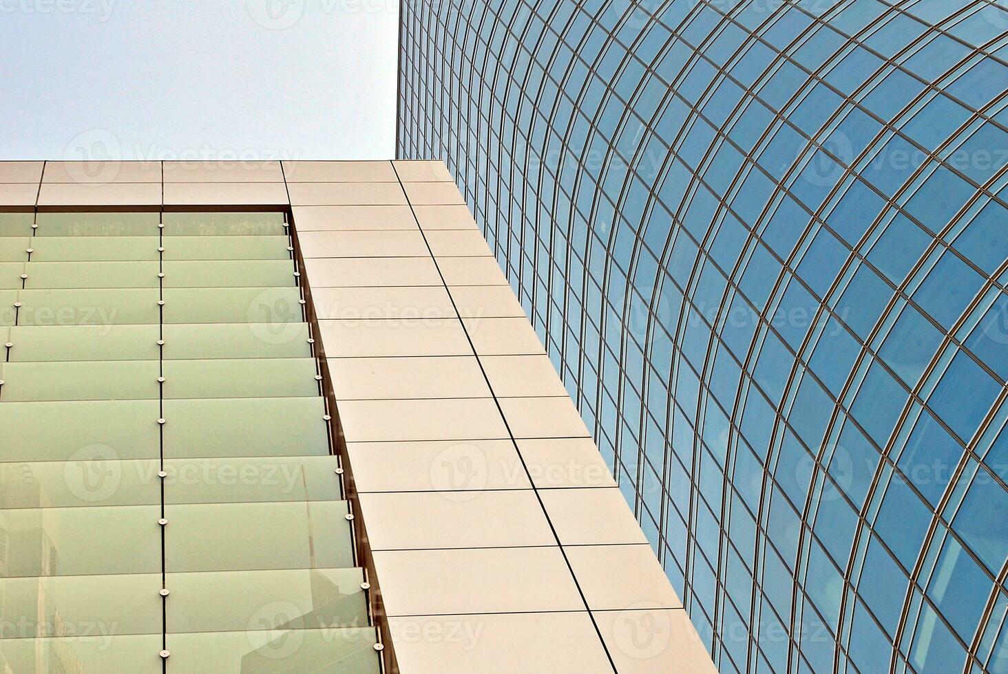 Structural glass wall reflecting blue sky. Abstract modern architecture fragment. photo