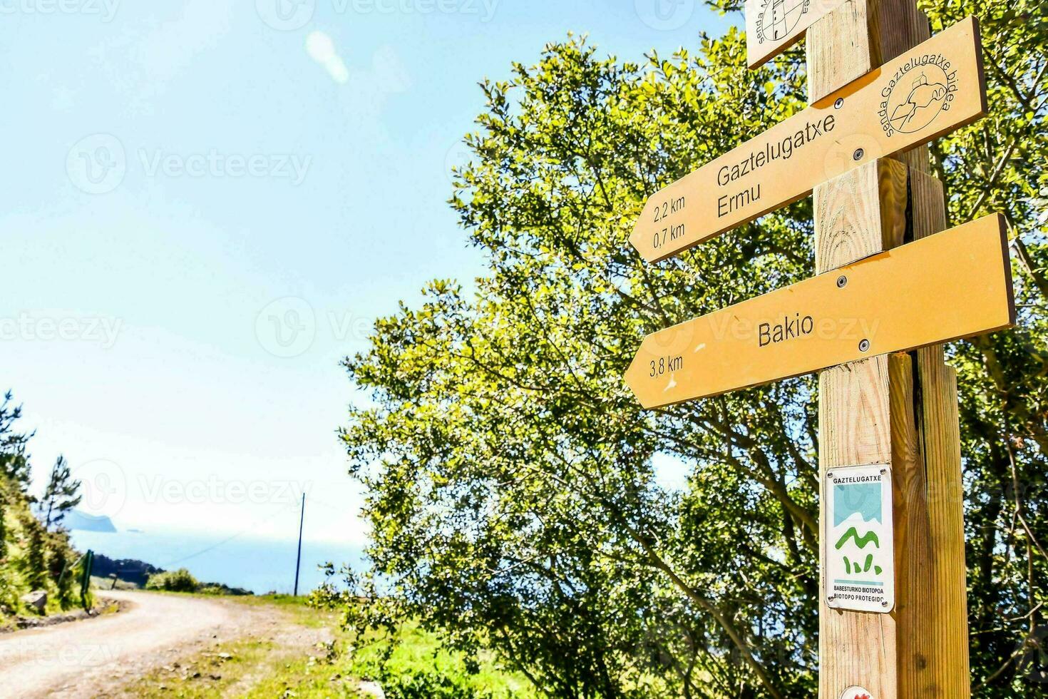 a wooden sign pointing to the direction of the trail photo