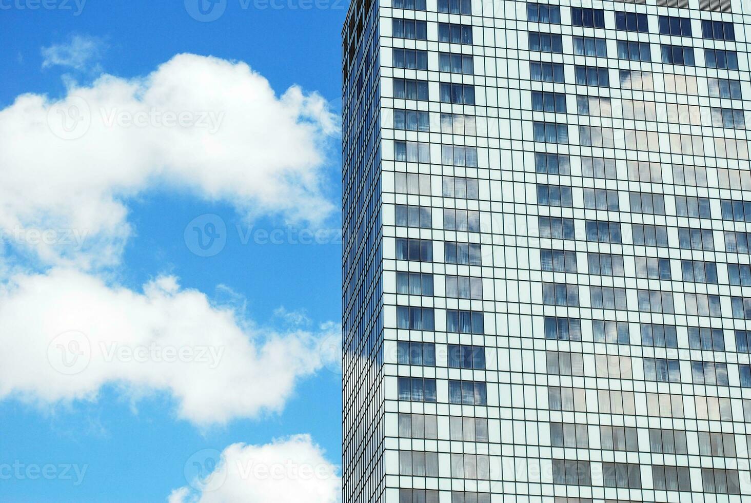 Structural glass wall reflecting blue sky. Abstract modern architecture fragment. photo