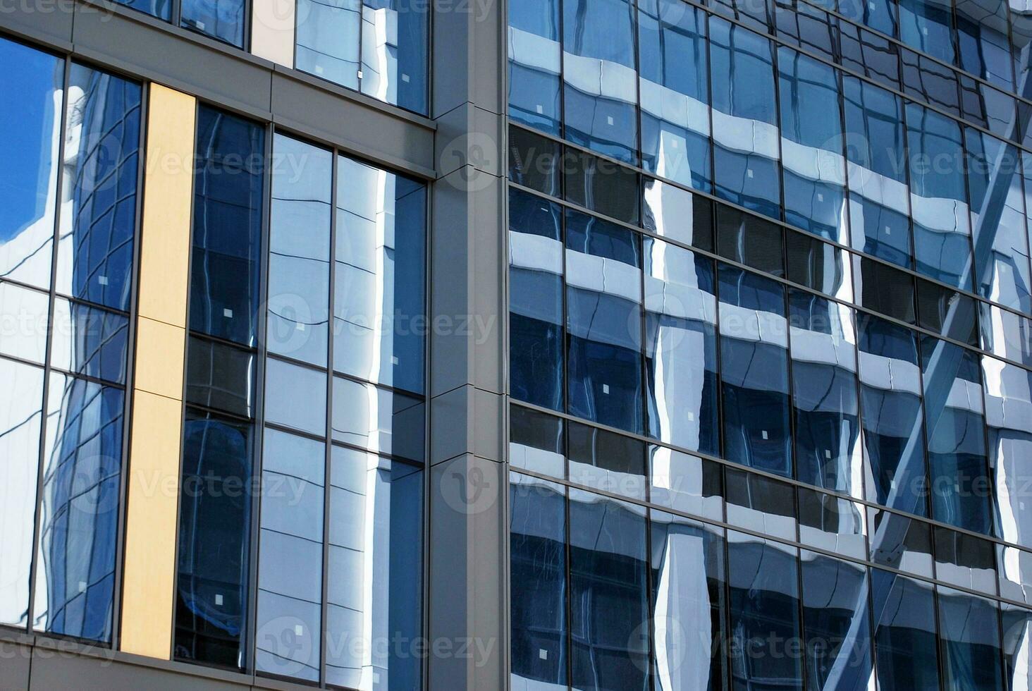 Structural glass wall reflecting blue sky. Abstract modern architecture fragment. photo