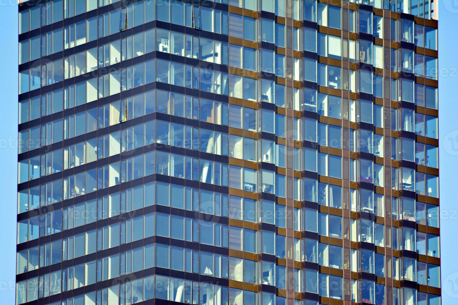 Structural glass wall reflecting blue sky. Abstract modern architecture fragment. photo