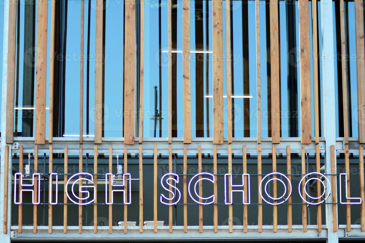 Structural glass wall reflecting blue sky. Abstract modern architecture fragment. photo