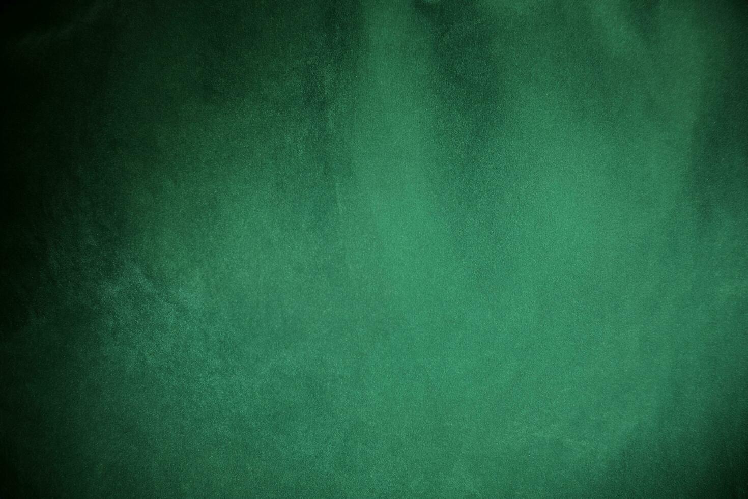 Green velvet fabric texture used as background. Emerald color panne fabric background of soft and smooth textile material. crushed velvet .luxury emerald tone for silk.. photo