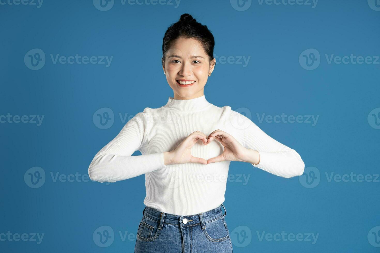 Portrait of beautiful asian woman posing on blue background photo