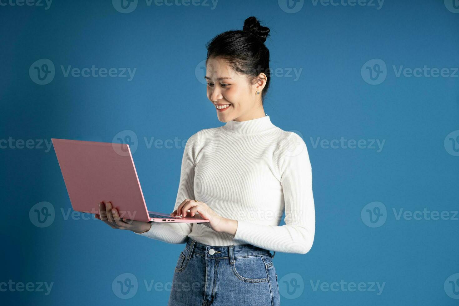 Portrait of beautiful asian woman posing on blue background photo