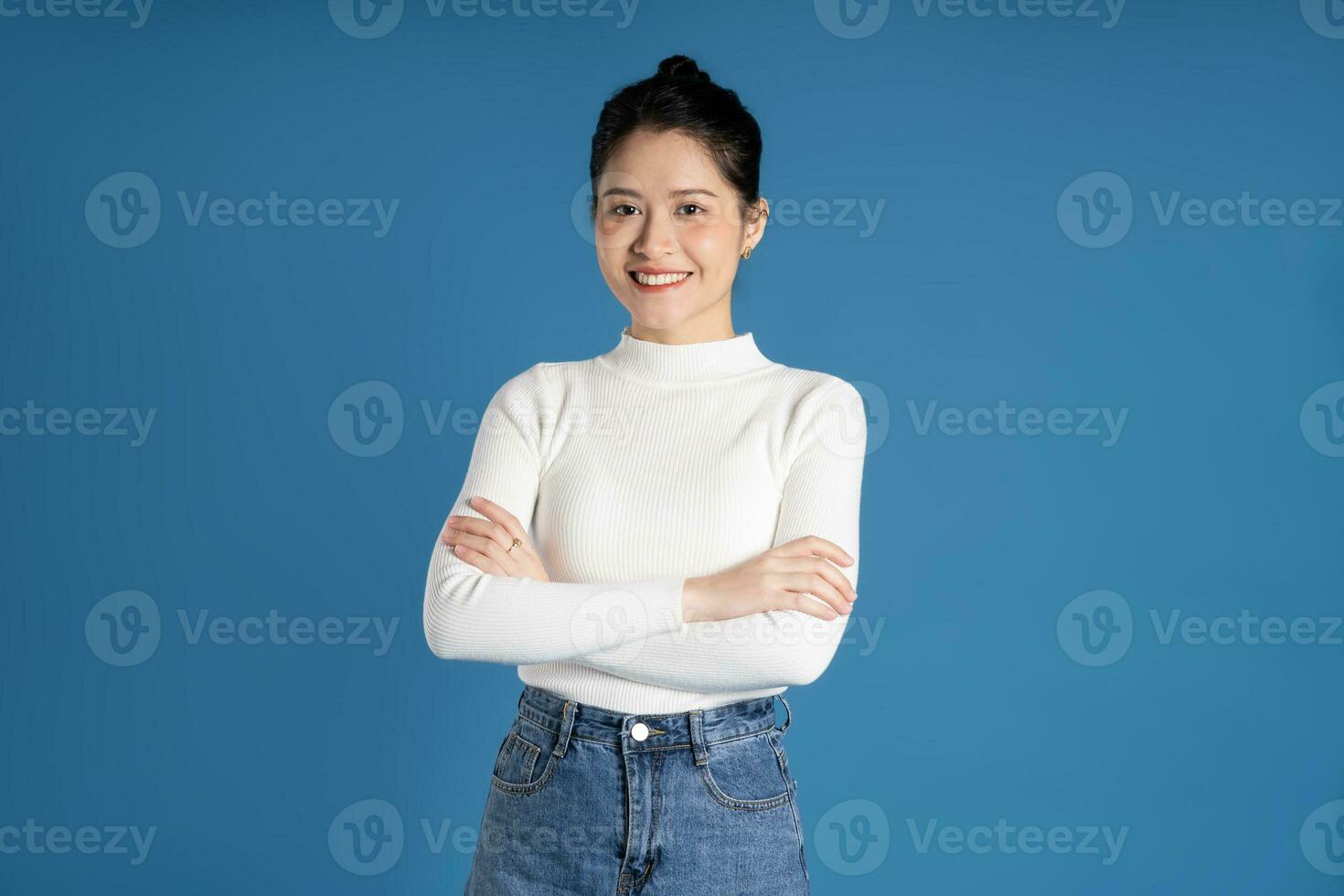 retrato de hermosa asiático mujer posando en azul antecedentes foto