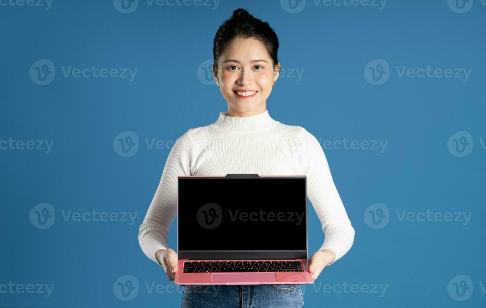 Portrait of beautiful asian woman posing on blue background photo