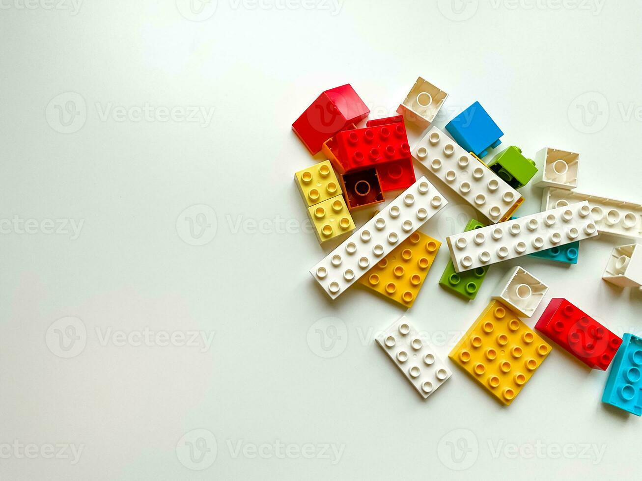 Top view of colorful plastic building blocks on white background with copy space photo