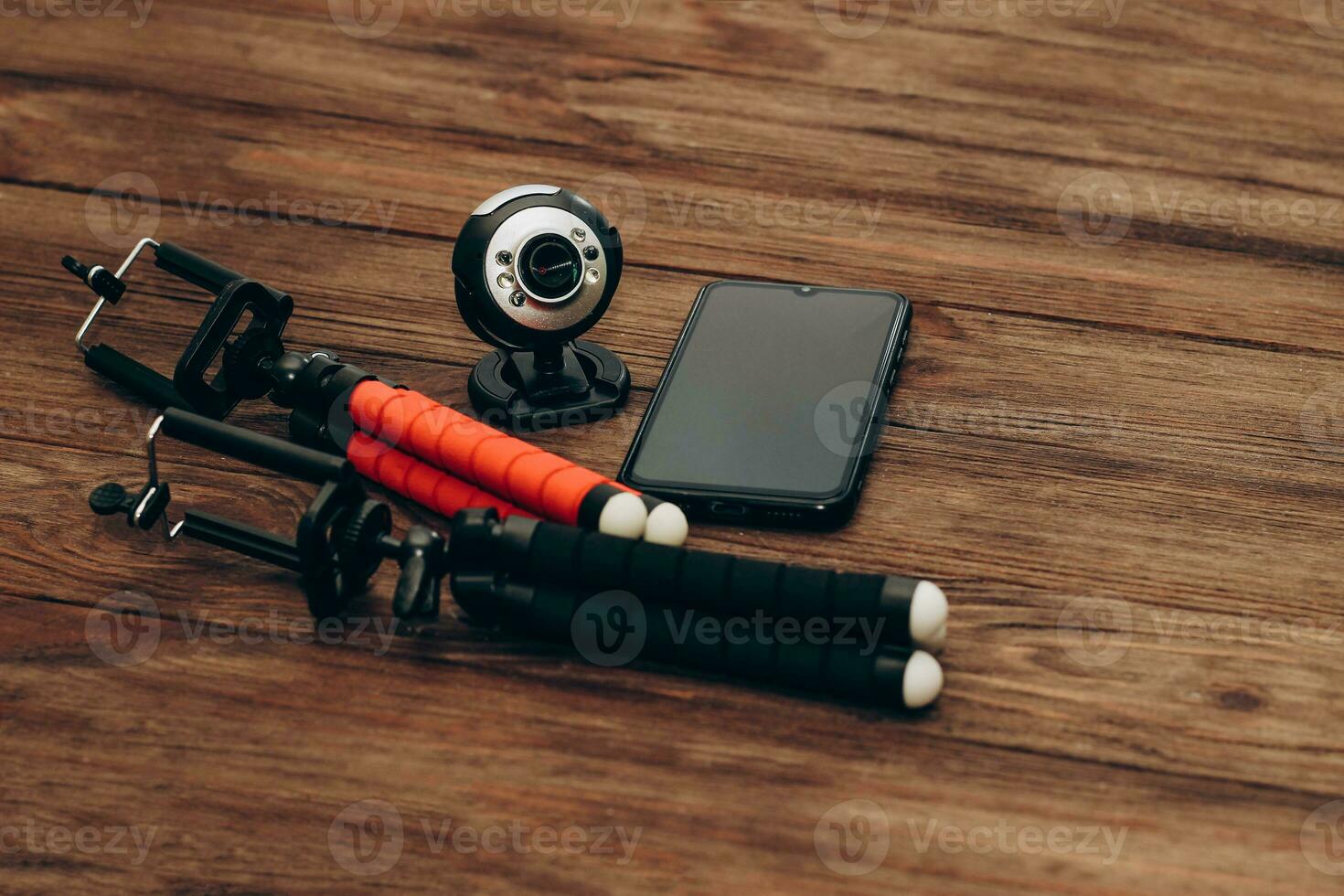 Two manual tripod monopods for a phone or a small camera on a wooden table. photo
