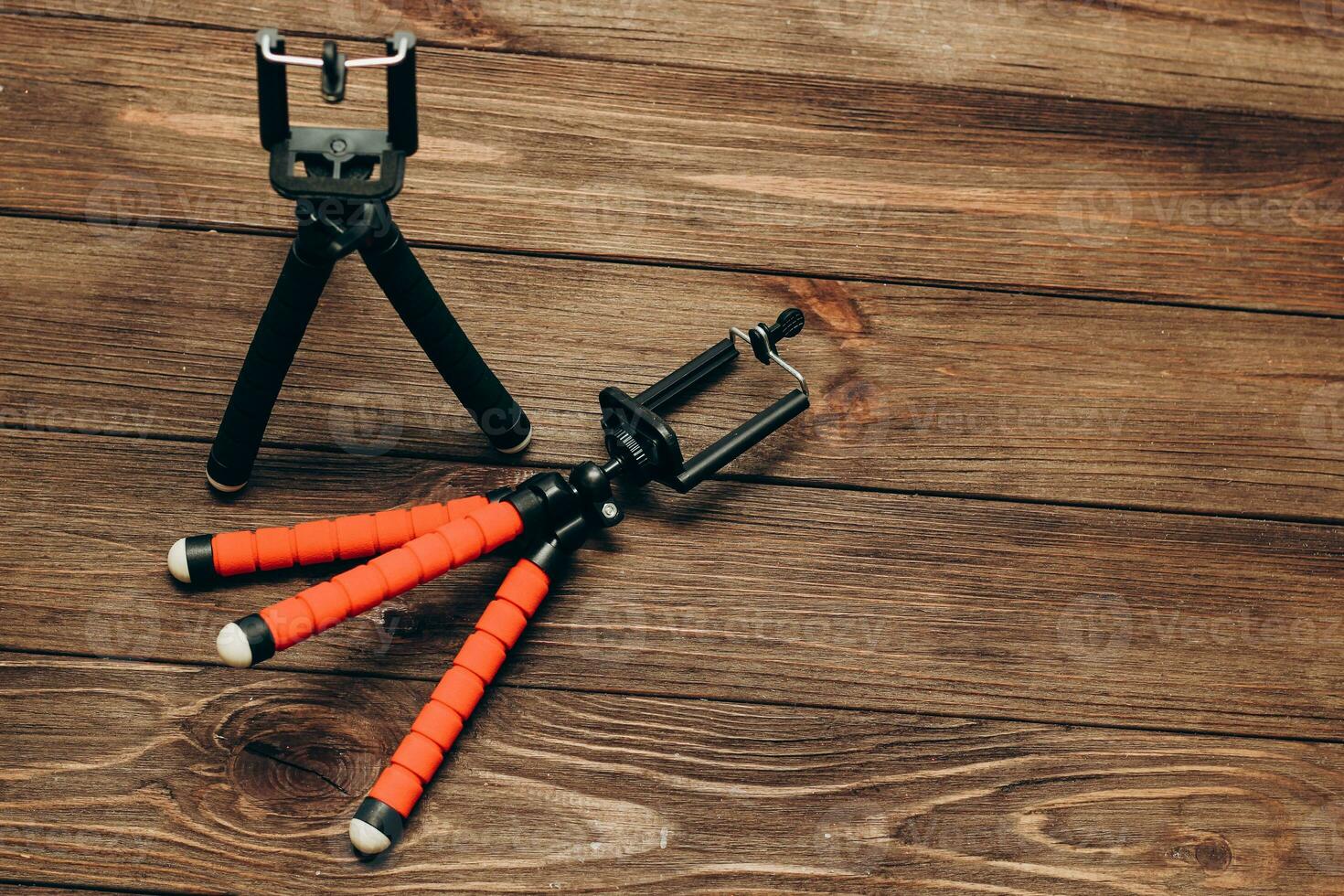 Two manual tripod monopods for a phone or a small camera on a wooden table photo