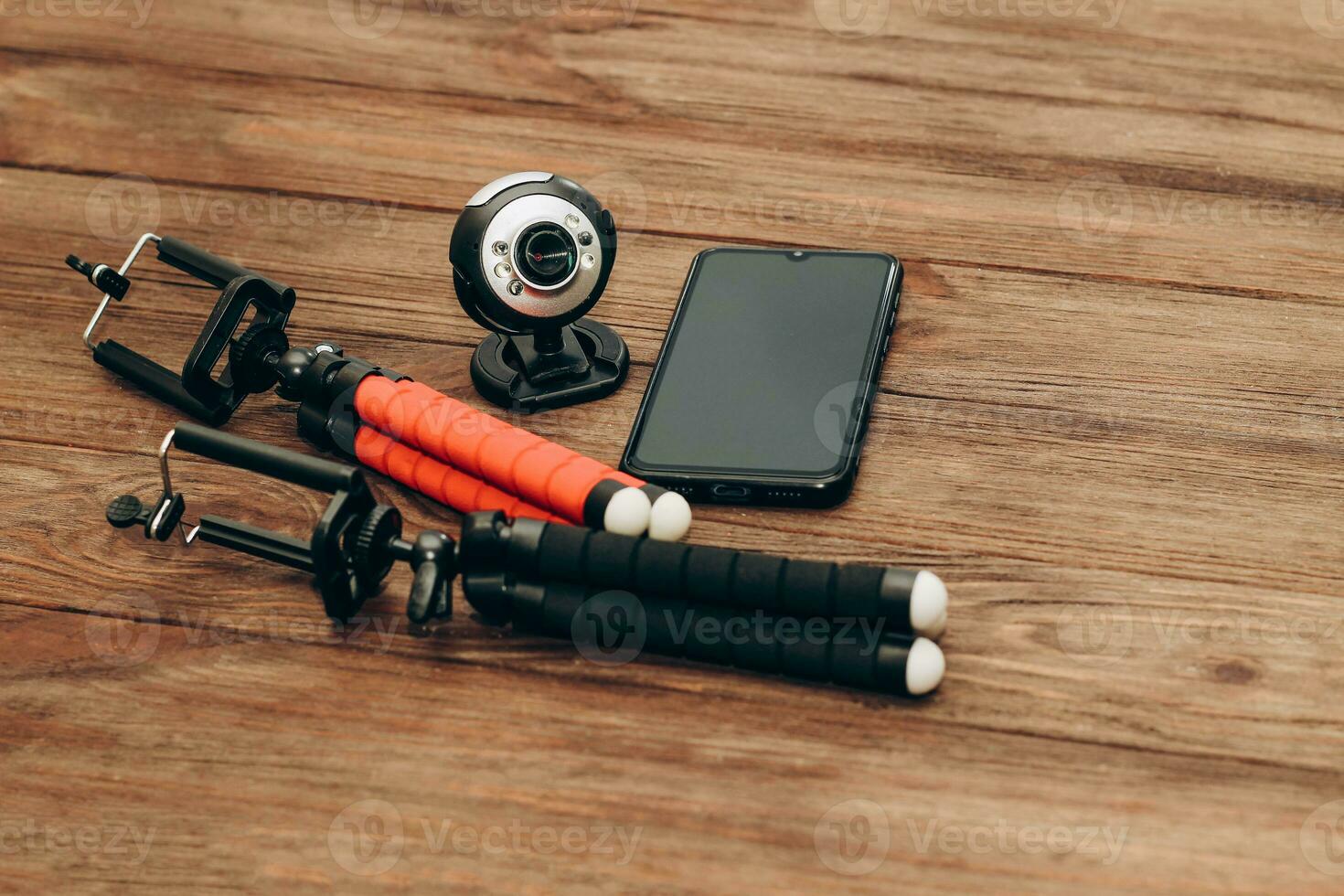 Two manual tripod monopods for a phone or a small camera on a wooden table photo