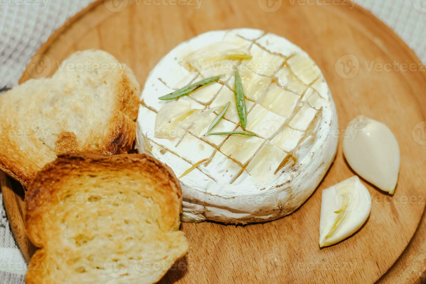 White baguette cut into pieces with olive oil and Camembert cheese on the table photo