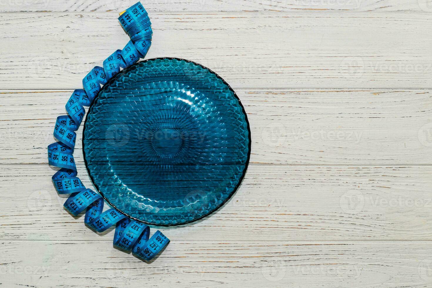 empty blue plate with centimeter on background, diet proper nutrition concept. photo