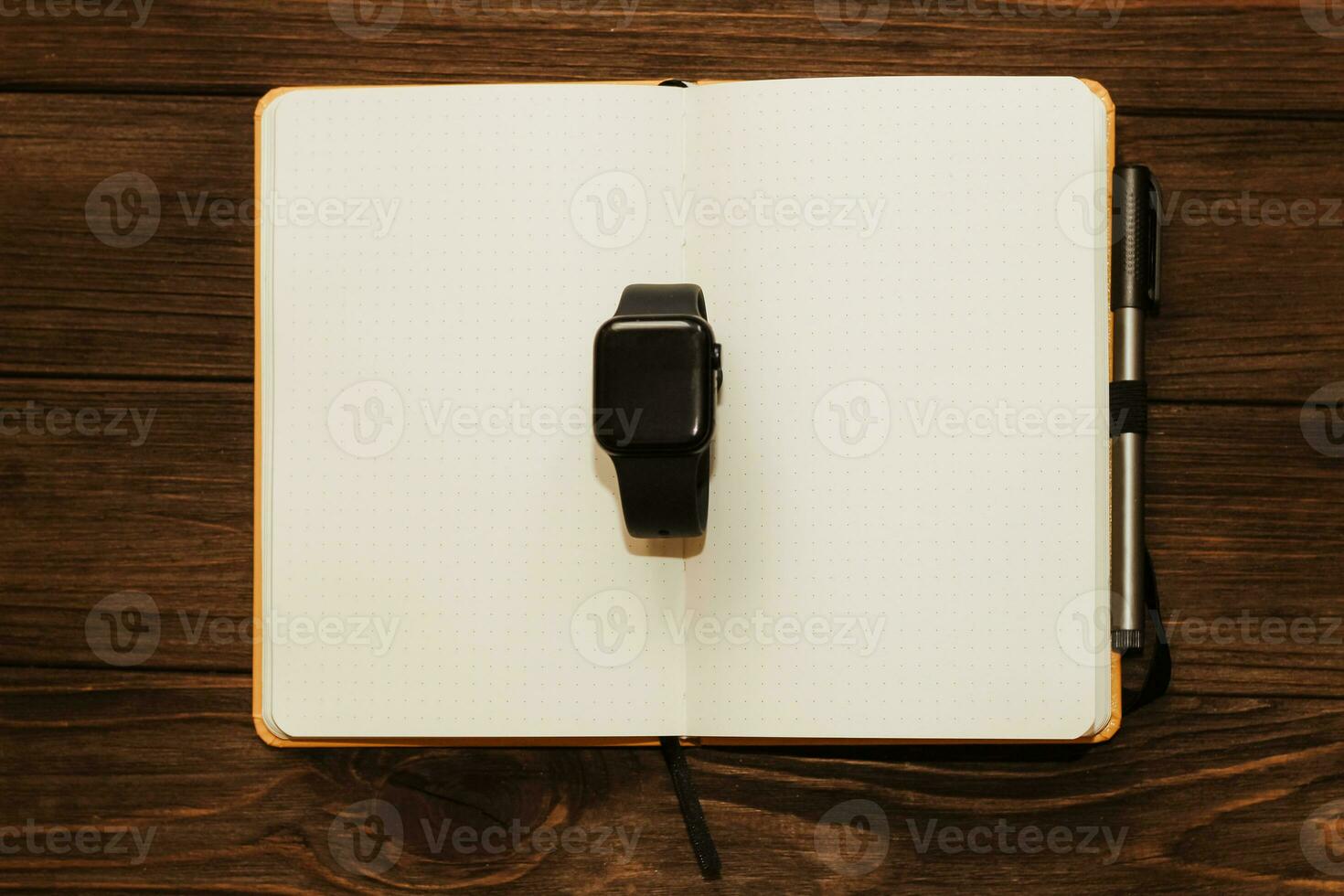 Open notebook diary with clock with black dial, time management concept. photo