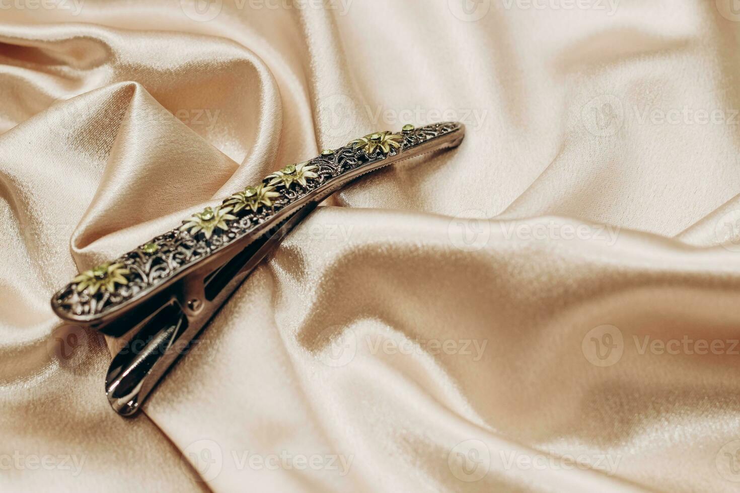 Vintage bronze hair clip with sapphires on a silk background. photo