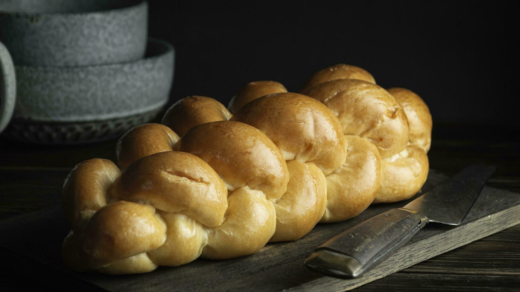 a loaf of bread on a cutting board with a knife photo