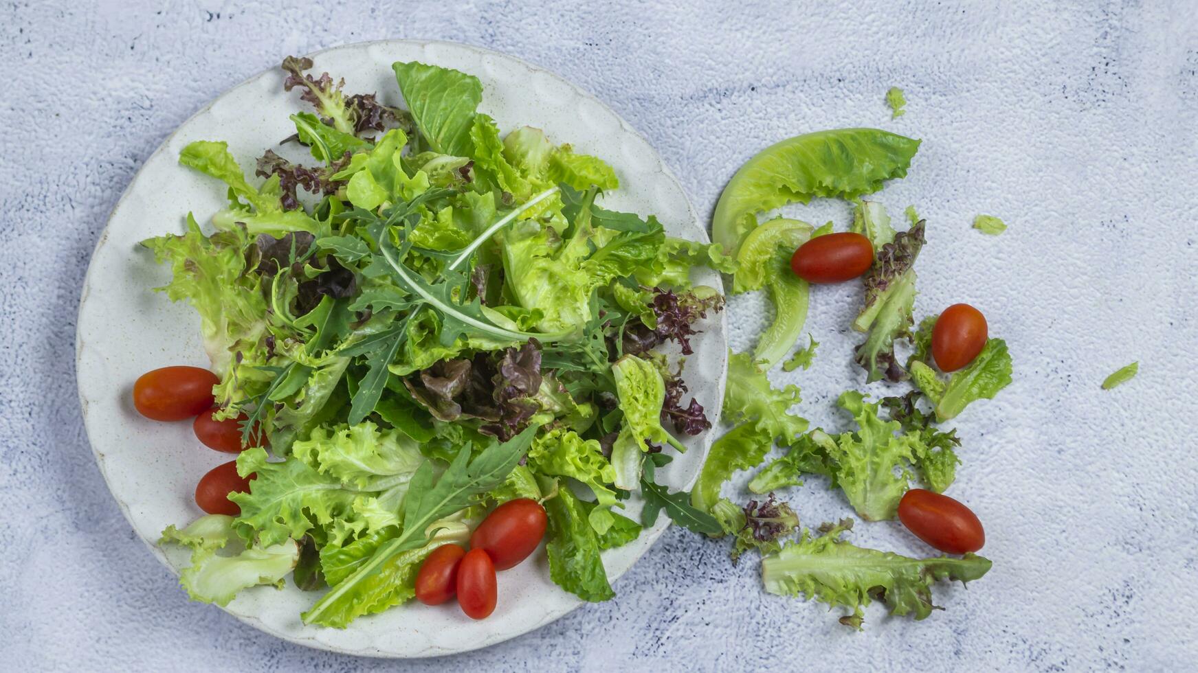 a plate with a salad and tomatoes on it photo