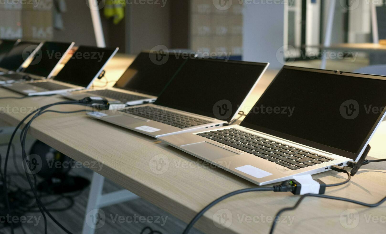 Row of laptops being prepared and set up for new employees in a company photo