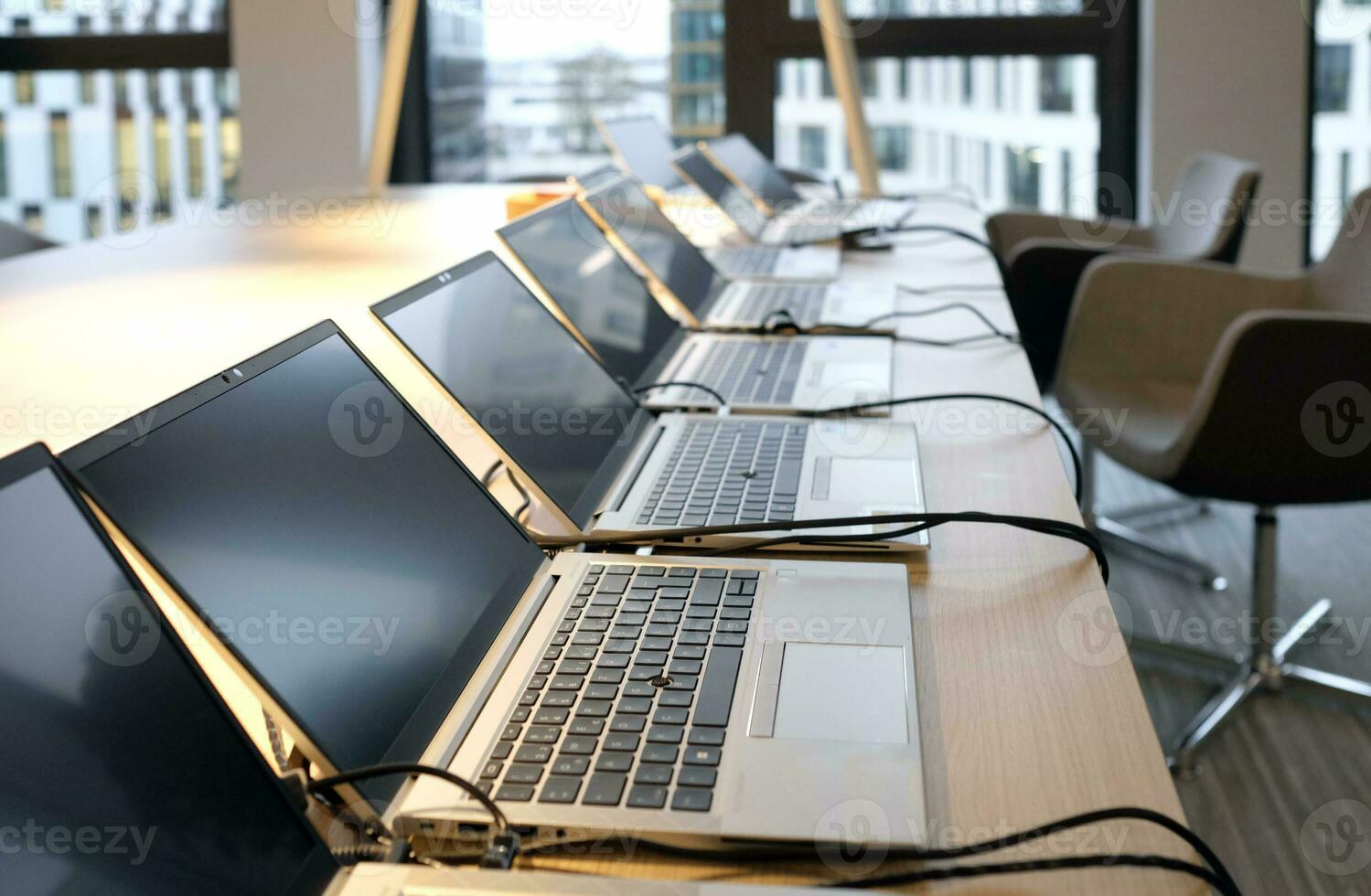 Row of laptops being prepared and set up for new employees in a company photo