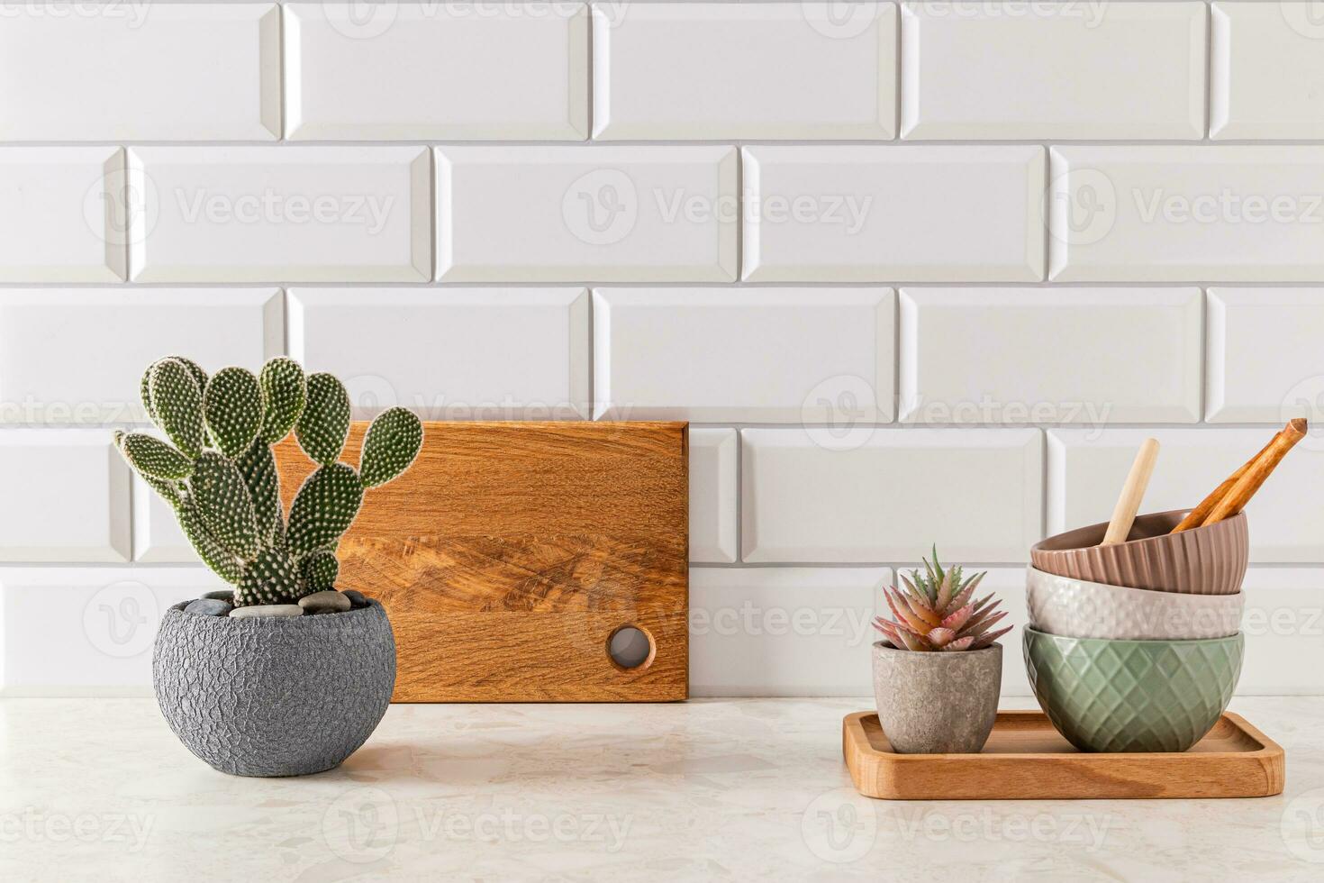 elegante moderno cocina antecedentes con conjunto de cerámico bochas y verde Opuntia cactus en maceta. frente vista, minimalismo foto