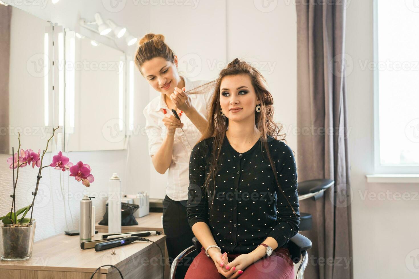 Hairdresser doing hair style for woman. Concept of fashion and beauty photo