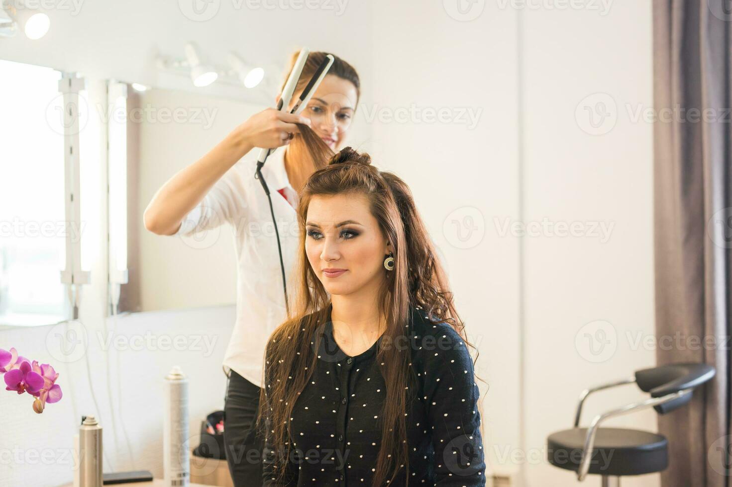 peluquero haciendo Corte de pelo para mujer en peluquería salón. concepto de Moda y belleza. positivo emoción. foto