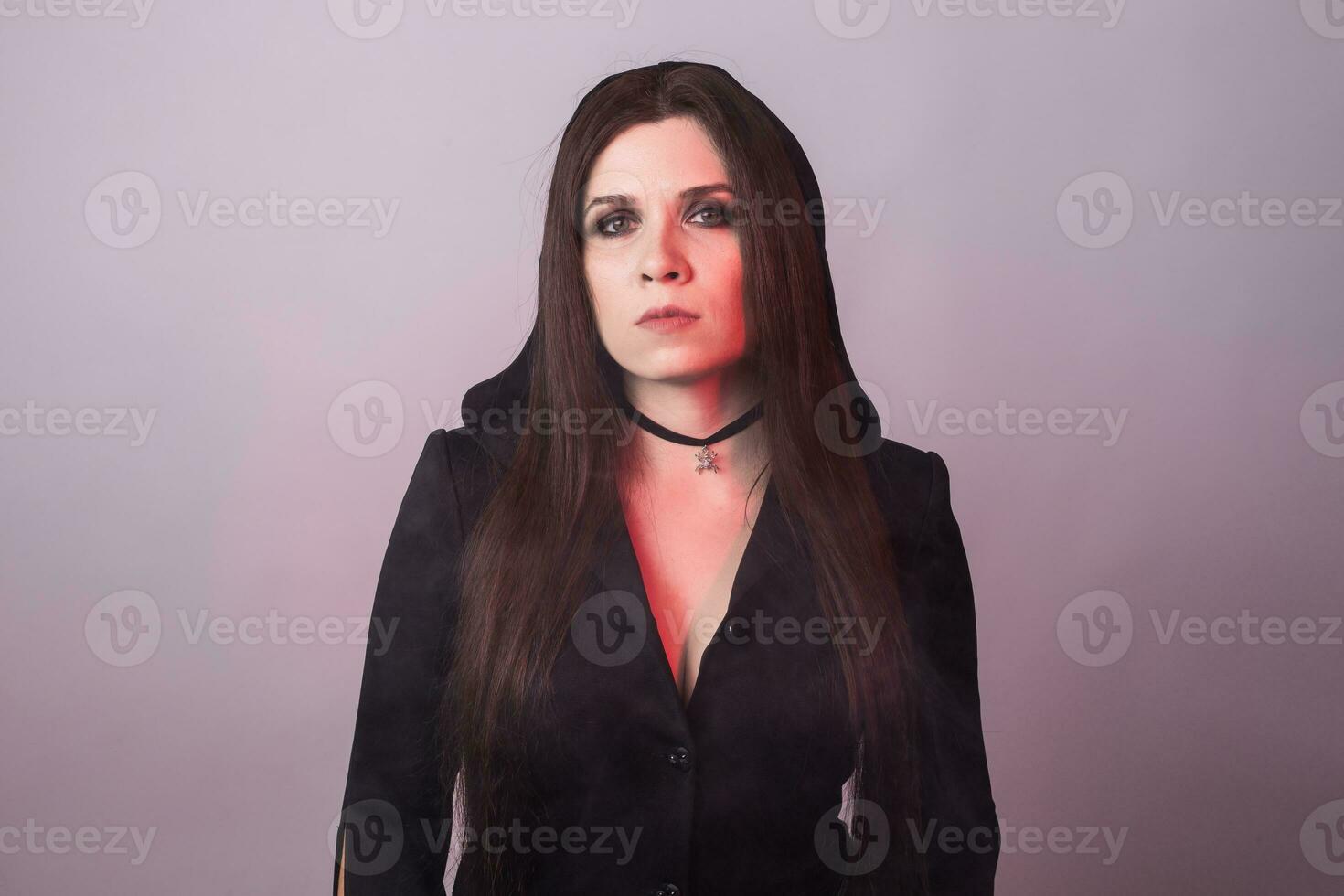 Gorgeous brunette with dark makeup. Halloween witch with smoke in studio photo