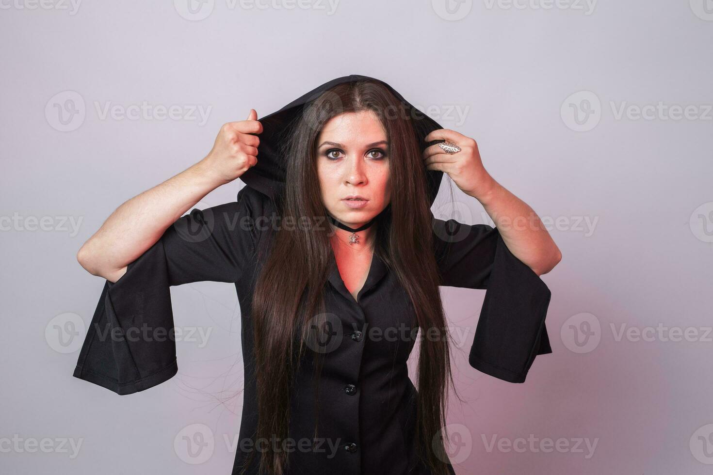 Gorgeous brunette with dark makeup. Halloween witch with smoke in studio photo