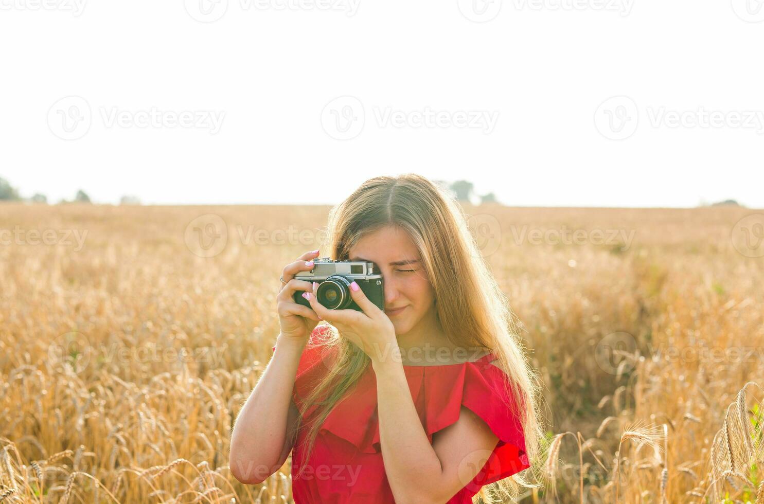 photographer with camera taking picture in the field. photo