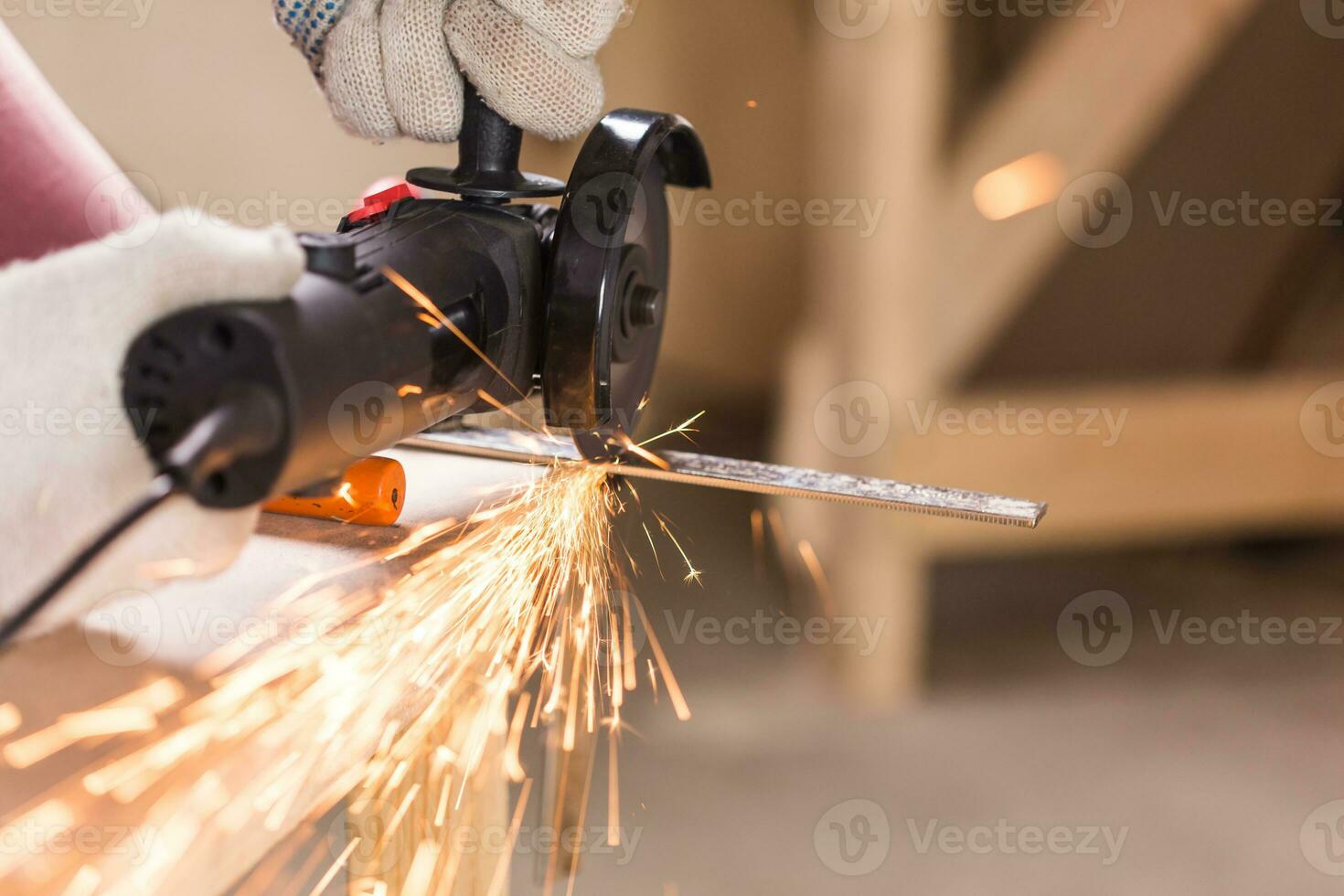 Heavy industry worker cutting steel with angle grinder photo