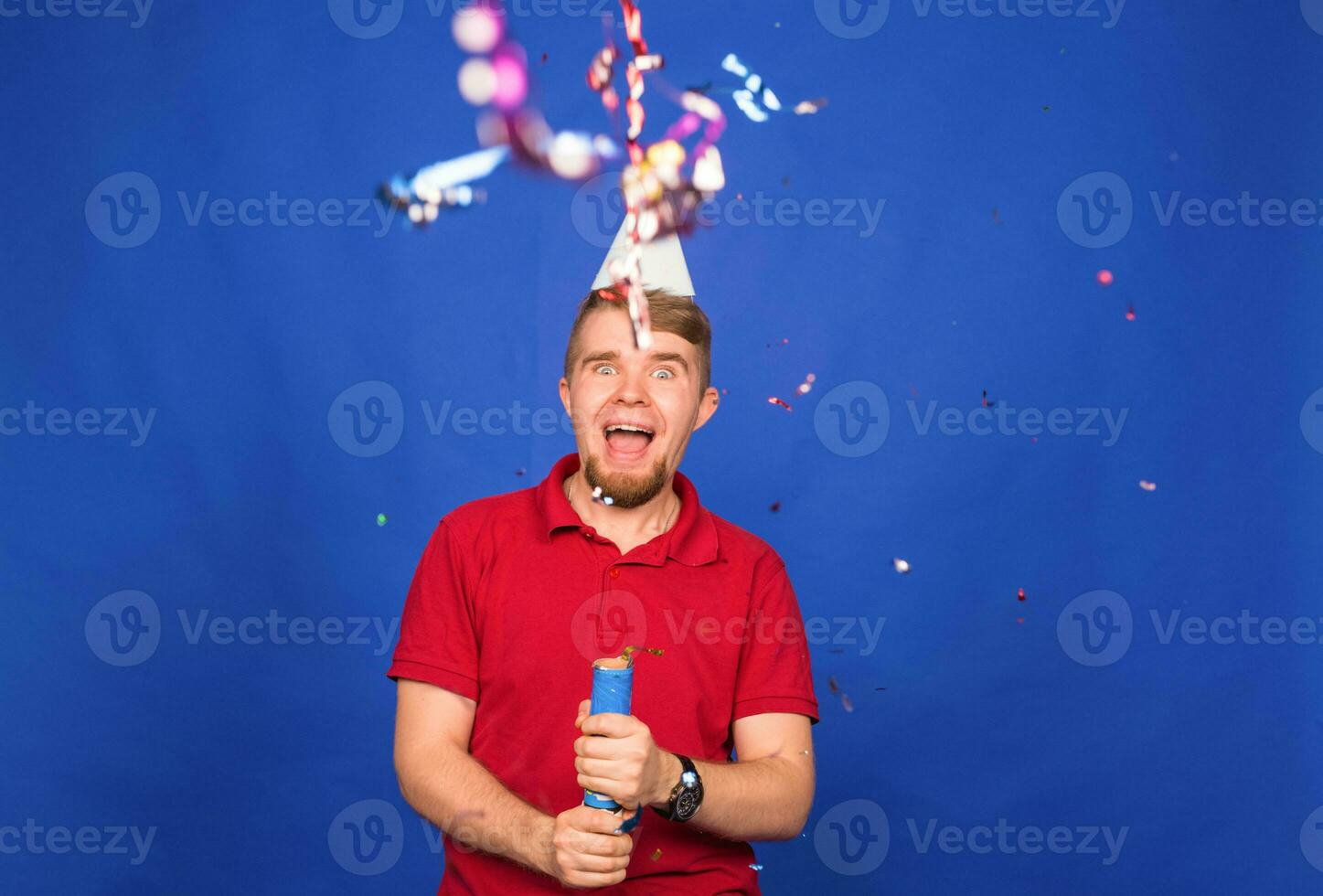 Young funny man celebrating new year and christmas party with confetti photo