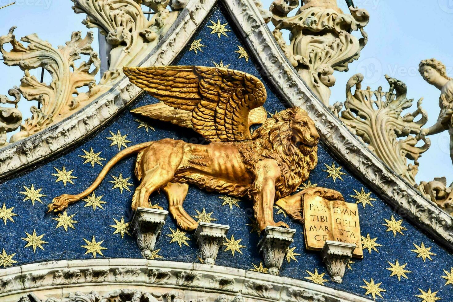 golden lion statue on the roof of a building in venice photo