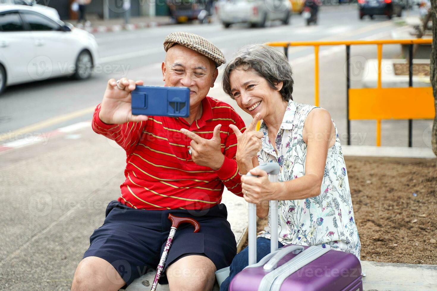 Senior Chinese tourist with his friend European poses happy and take a photo selfie on blurred of city background.