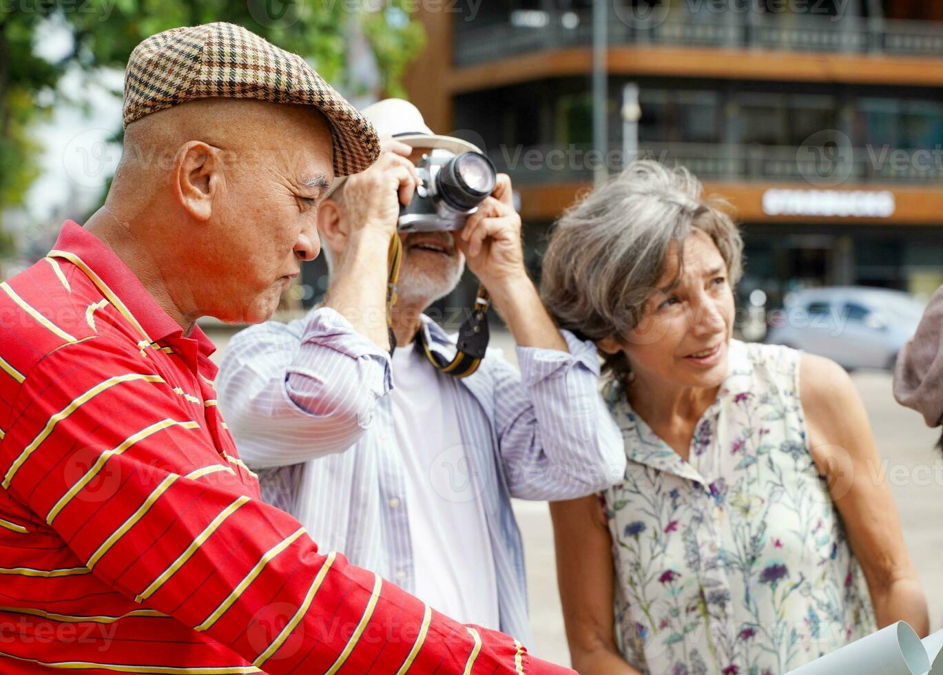 Senior Chinese tourist with his friend European tourist couple walking tour and take photos in the city