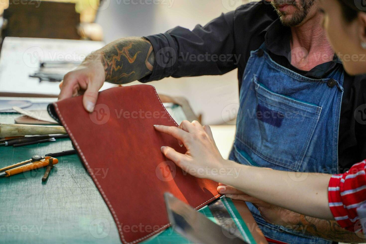 Closeup and crop hands of team of leather craftsman touching and check the neatness of the leathers bag before sell to customer in workshop. photo