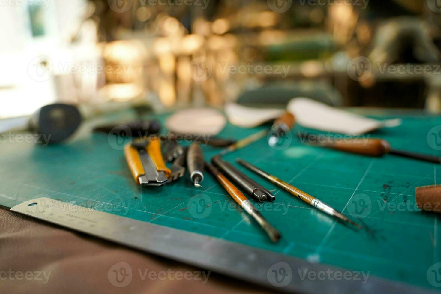 Closeup and crop tools and equipment for leather making on blurred background. photo