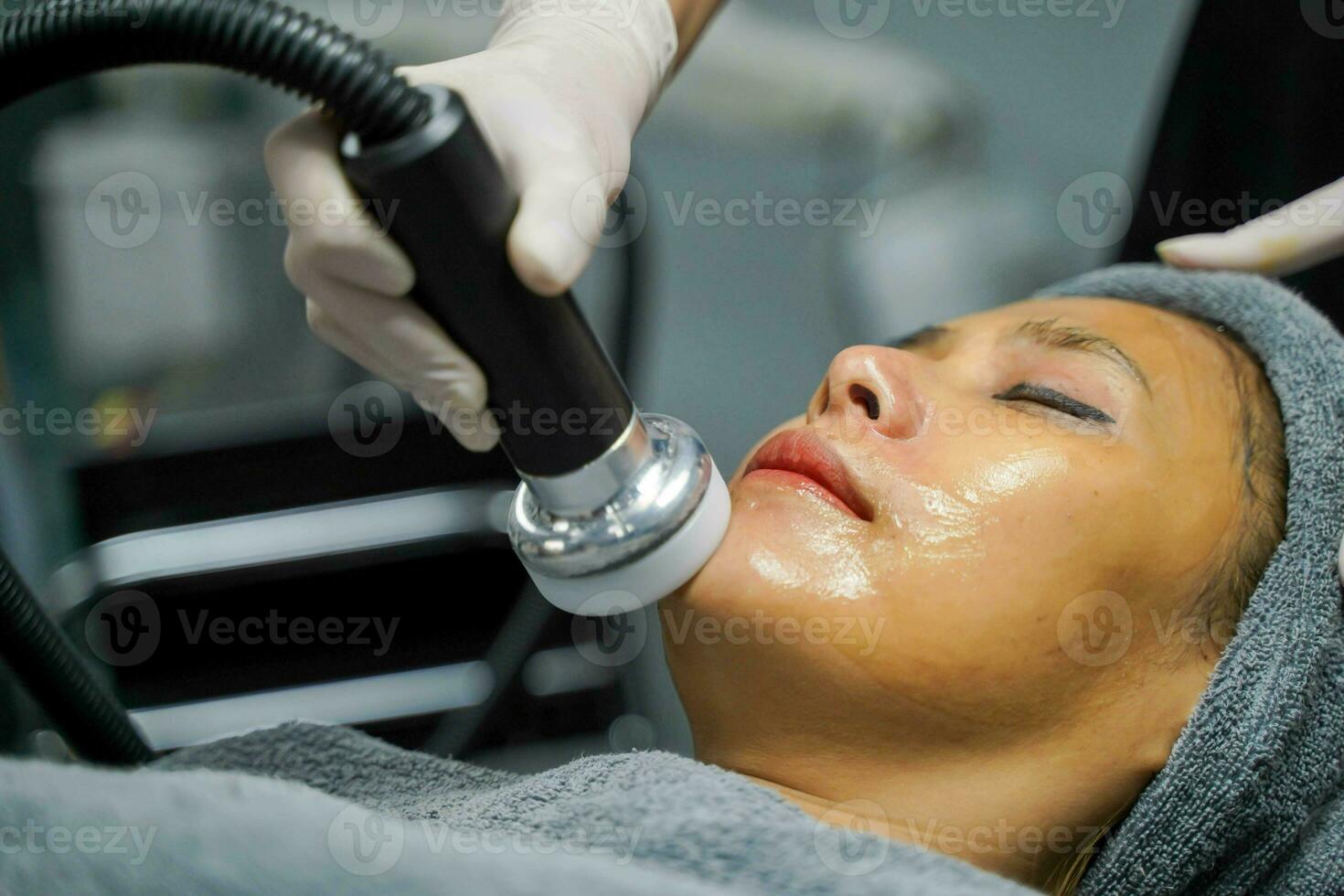 Closeup Asian beauty woman having therapy to stimulate facial skin and facial ultrasonic skincare treatment by professional cosmetologist wellbeing. photo