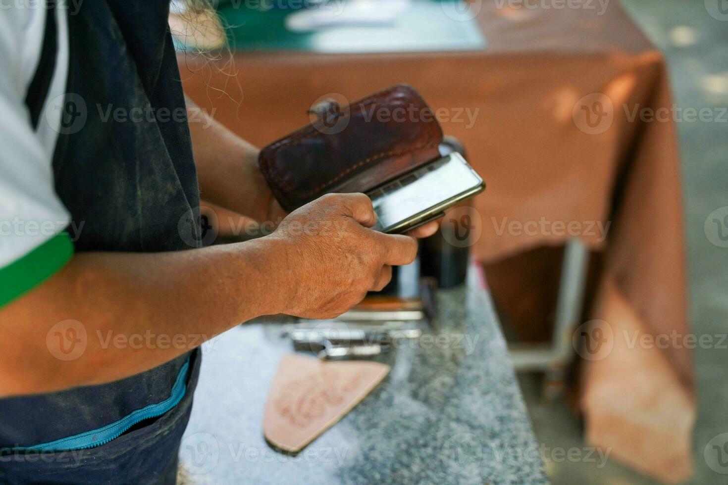 Closeup and crop leathers maker check an orders in his online shop. photo