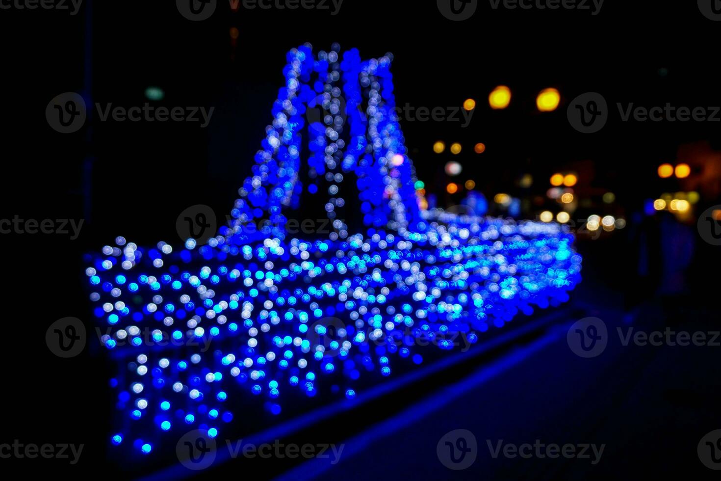 Blurred and bokeh of blue LED light bubs reflection lighting in boat shape at Osaka Bay Area. photo