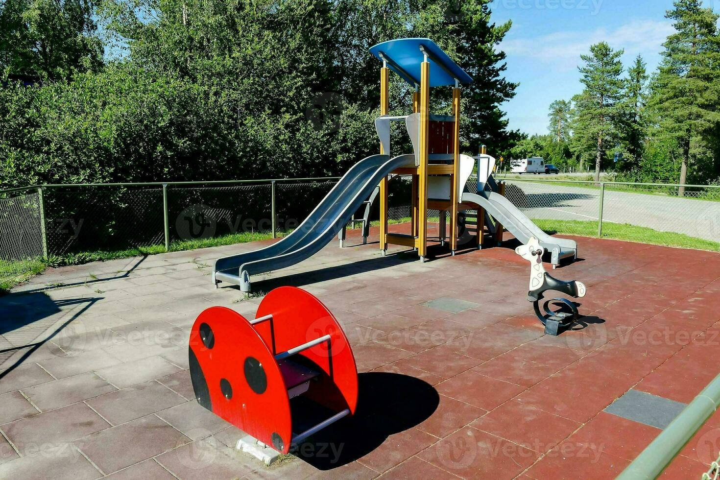 a playground with a slide and a ladybug ride photo
