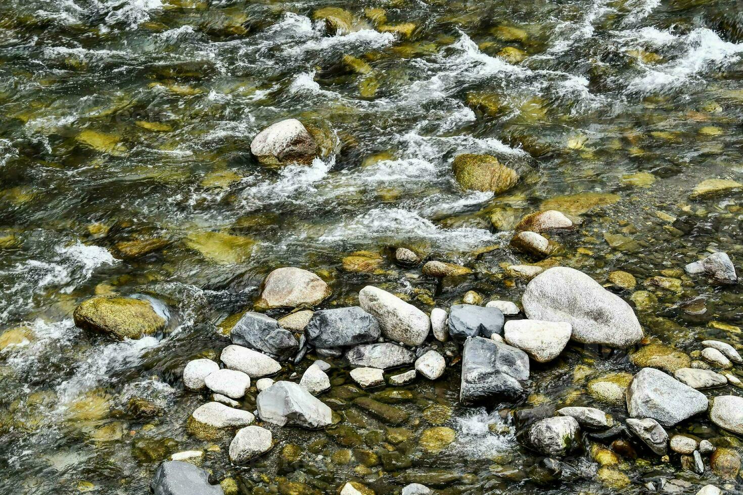 un río con rocas y agua fluido mediante eso foto