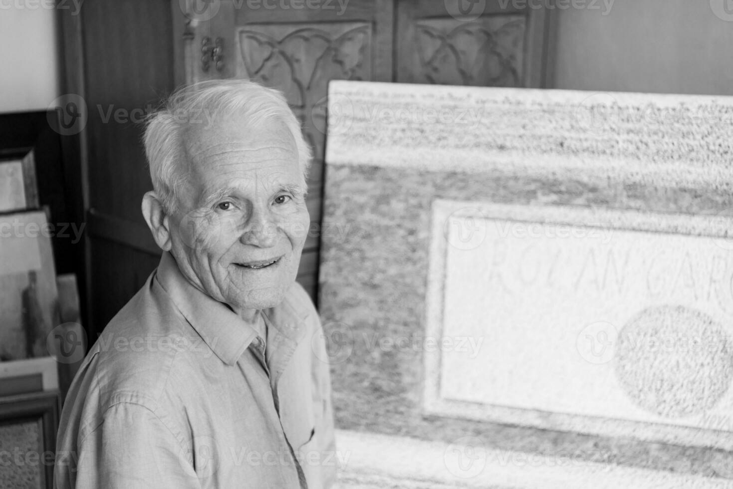 an older man is standing in front of a painting photo