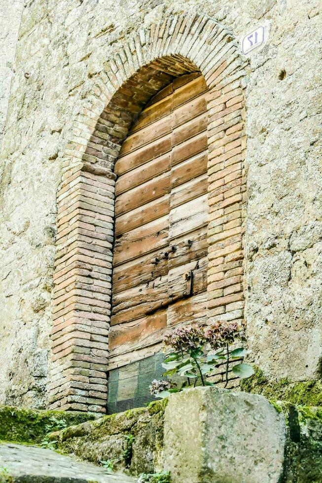 un antiguo de madera puerta en un Roca edificio foto