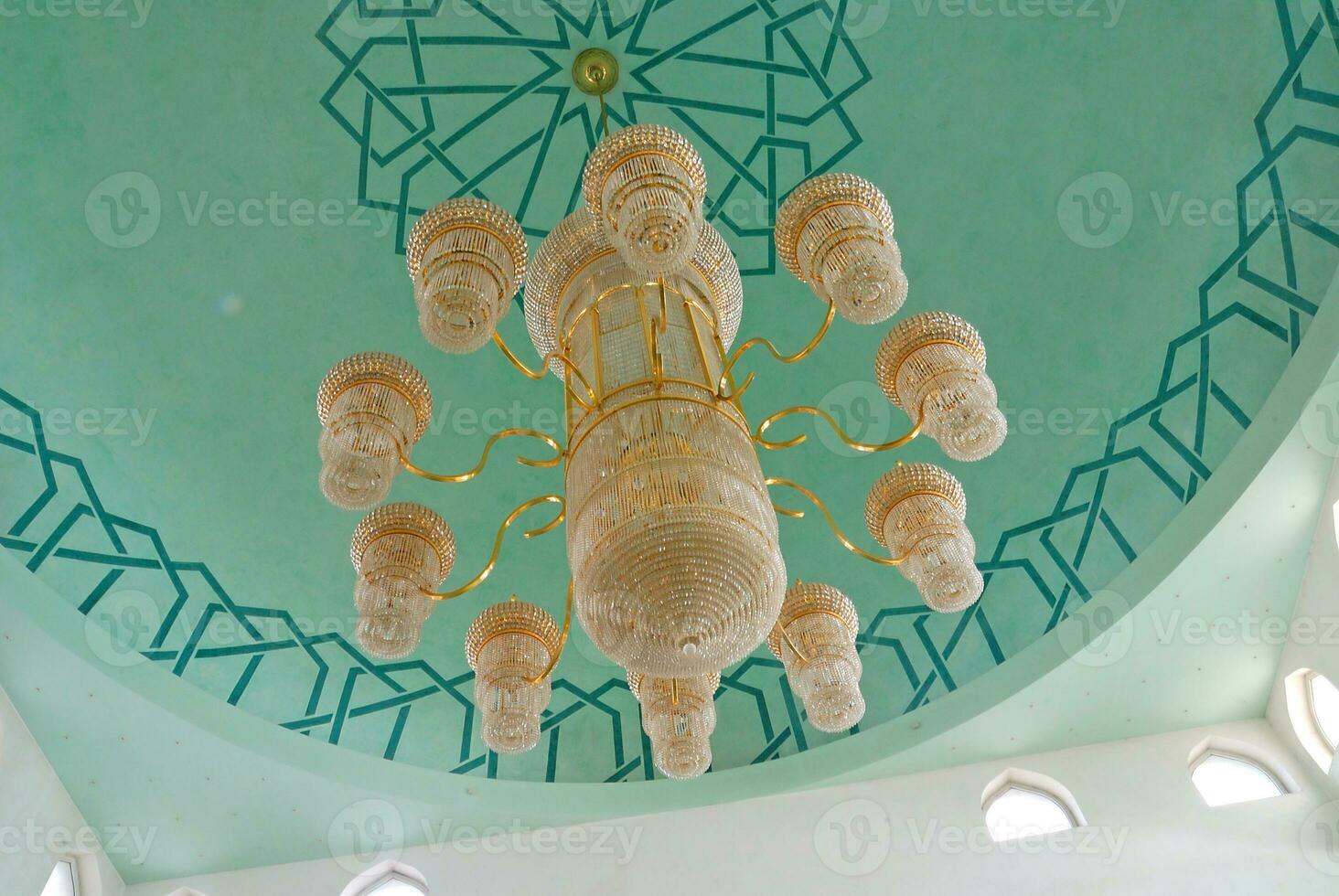 a chandelier in a mosque with a green ceiling photo