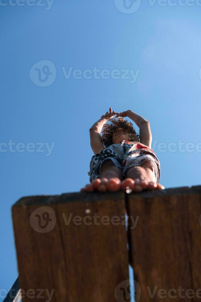 a man is standing on a wooden ledge photo