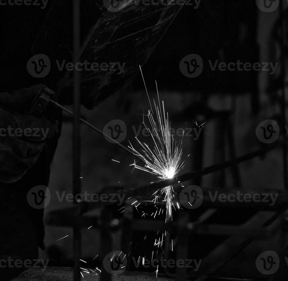 a black and white photo of a man welding