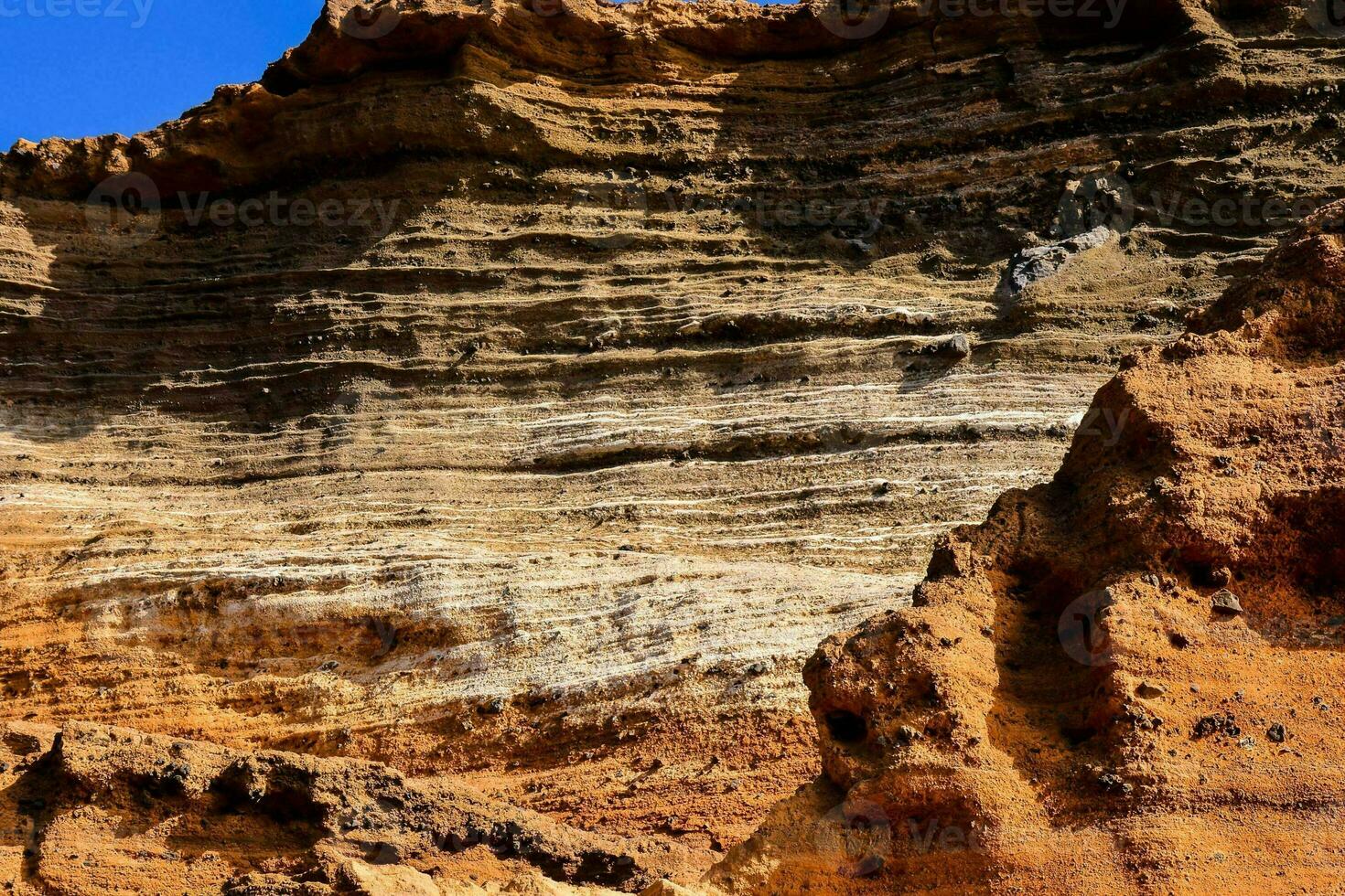a large rock formation in the desert with a blue sky photo