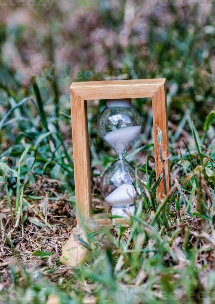 an hourglass sitting in the grass photo